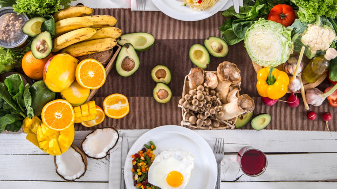 Fotografía cenital de una mesa con frutas, vegetales y platos de comida
