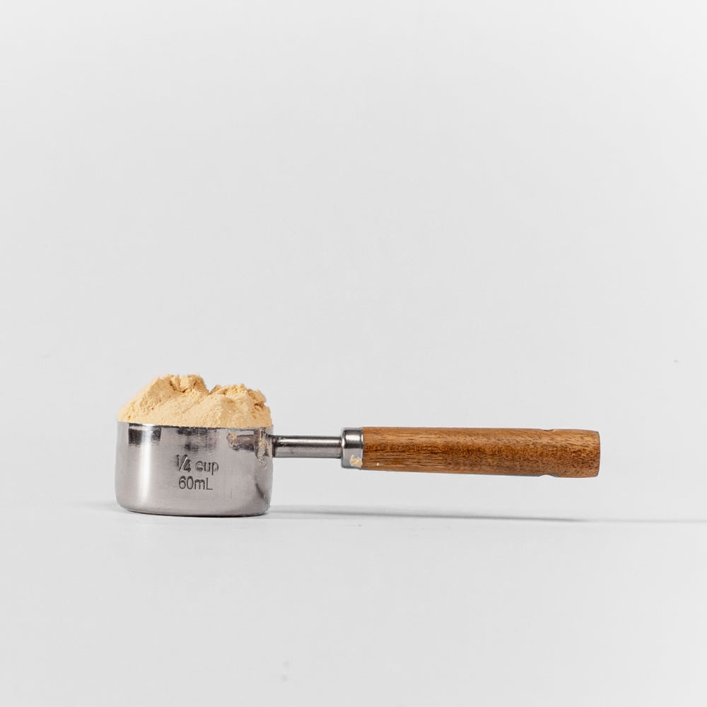vista lateral del scoop pura prote de 60 ml con polvo de proteína de arveja